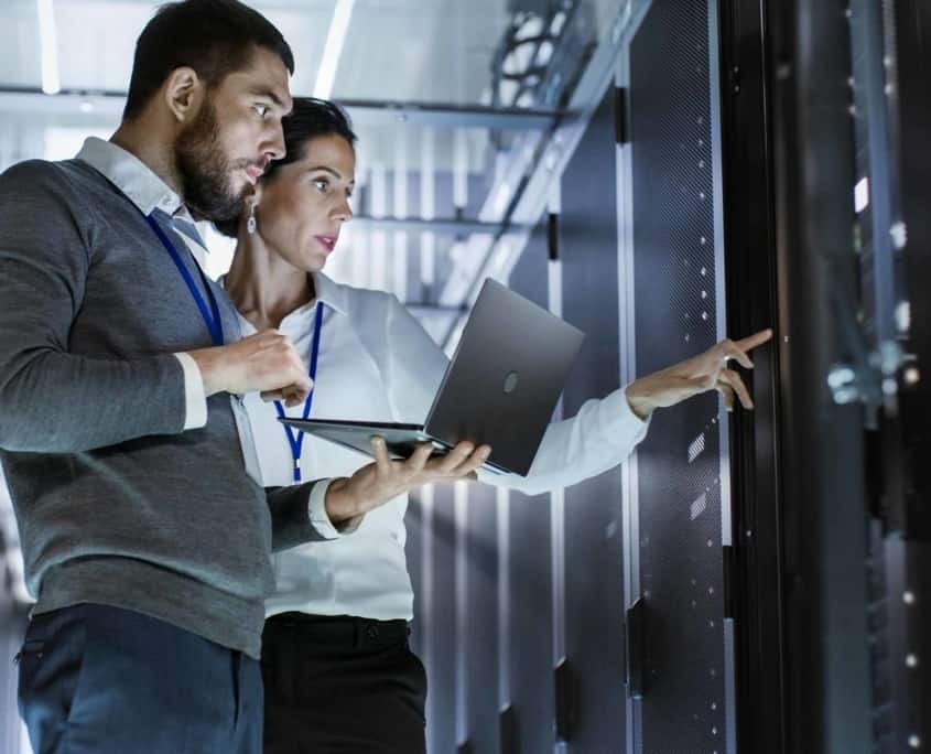 man and woman look at servers in data center