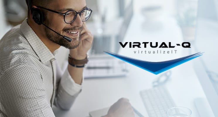 smiling man with headset and glasses in front of computer