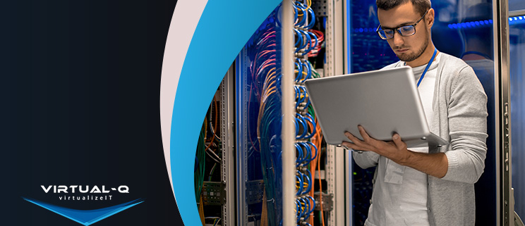 VirtualQ_March_LinkedIn_Article1 man holding laptop in data center next to multicolor background and Virtual-Q logo