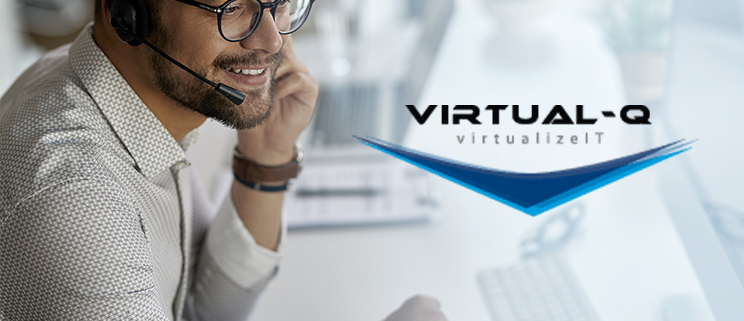 VirtualQ_March_LinkedIn_Article2 smiling man with headset and glasses in front of computer