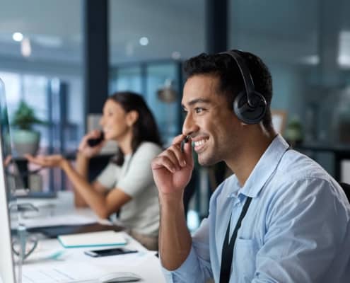 Image of a person in an IT center, talking to somebody over headset.